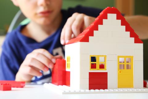 kid building lego house